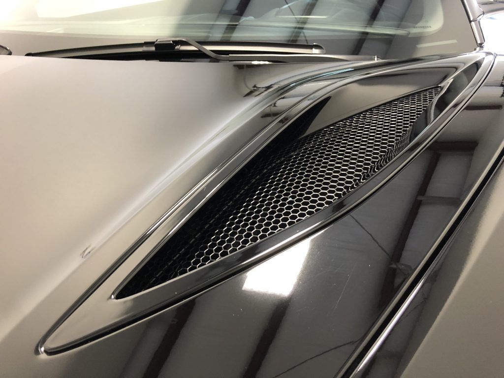 A close up of a car hood with a mesh grille
