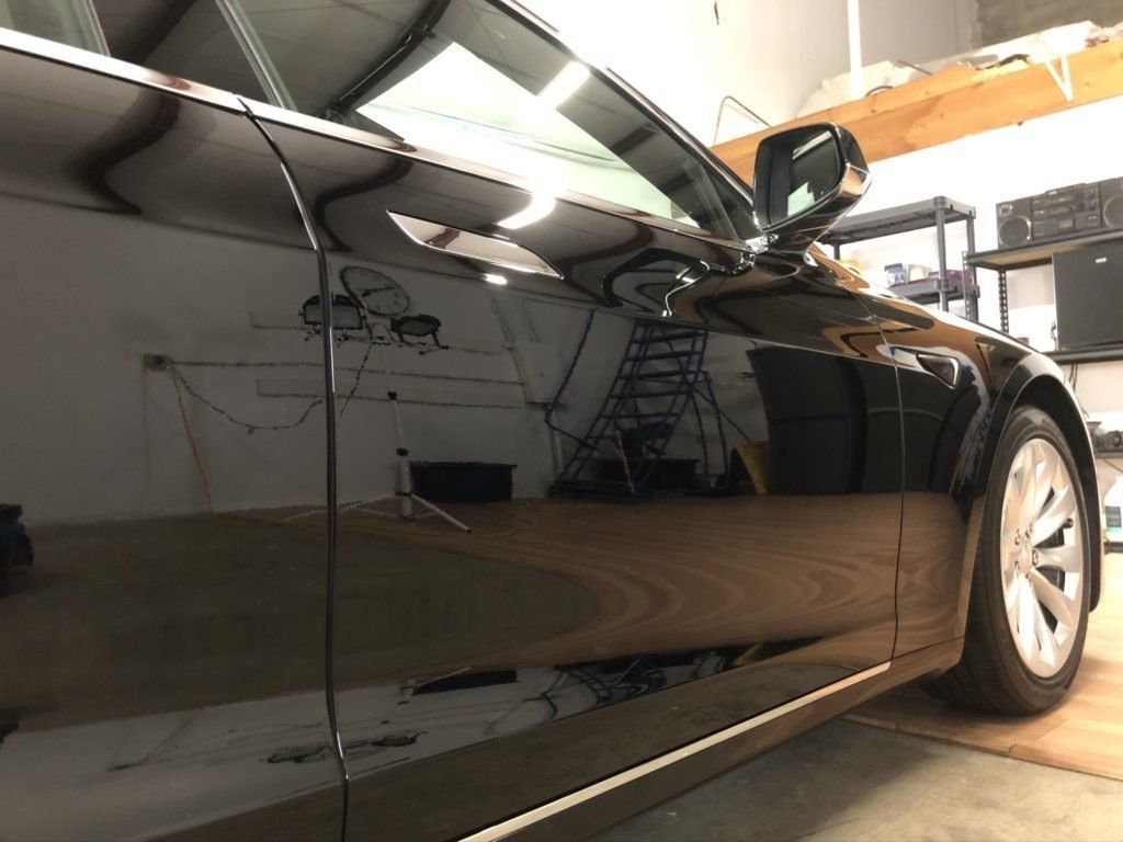 A black car is parked in a garage.