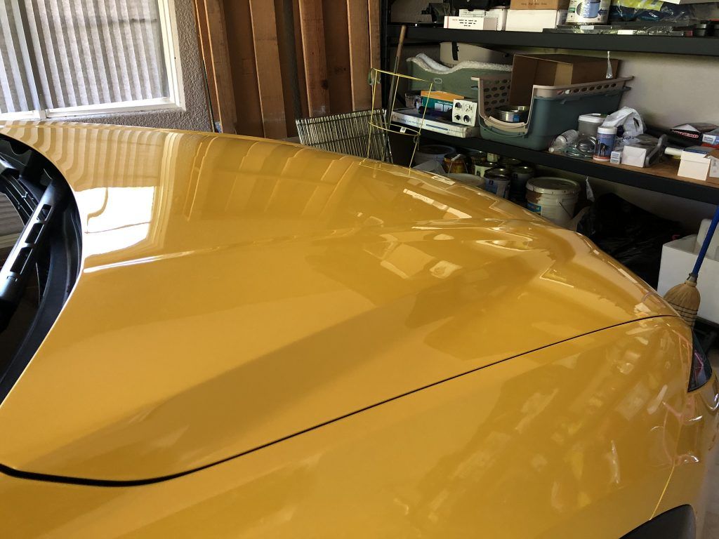 A yellow car is parked in a garage.