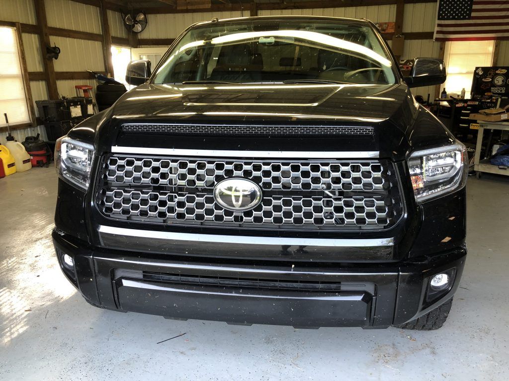 A black toyota tundra is parked in a garage.