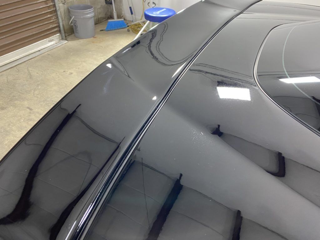 A close up of a car 's windshield in a garage.