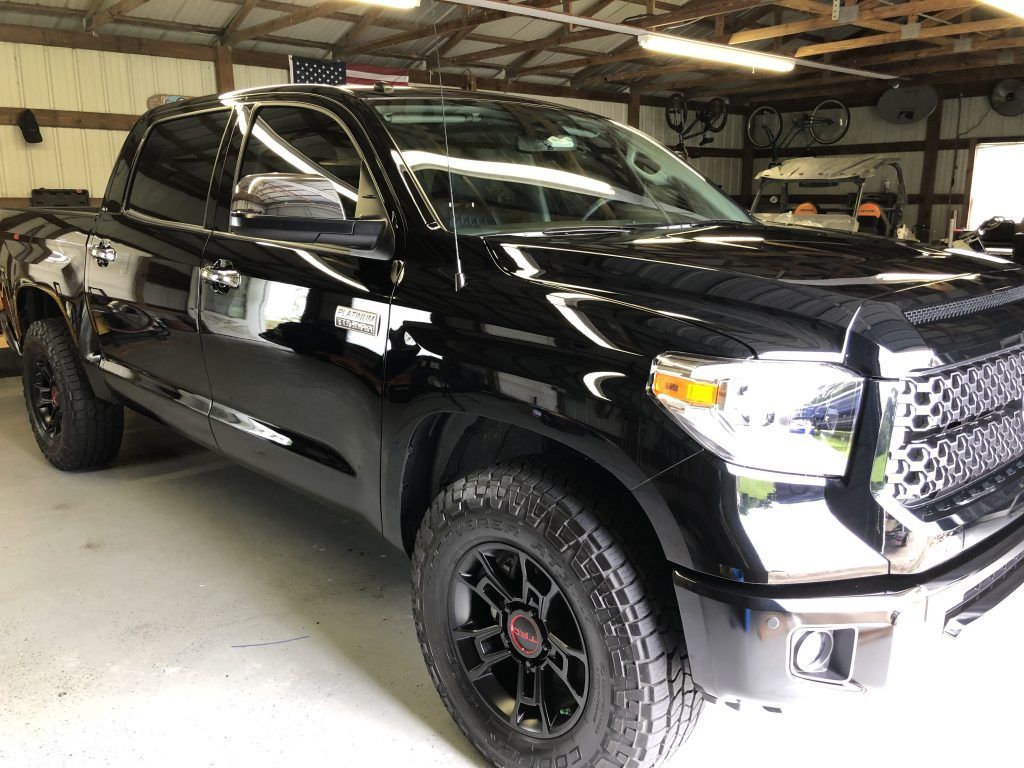 A black toyota tundra is parked in a garage.