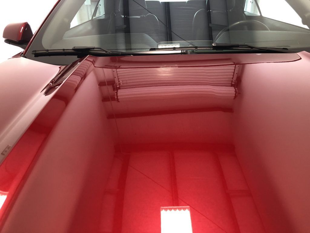 The inside of a red car with the hood up