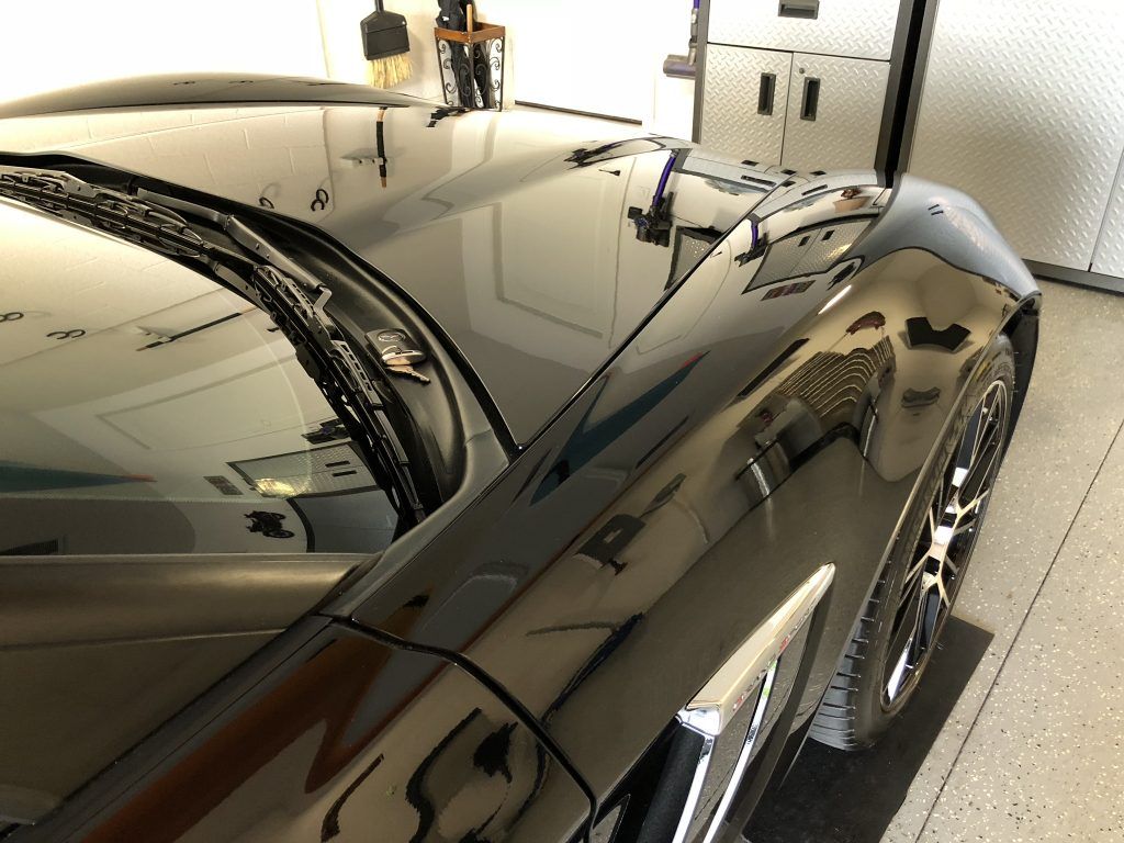 A black sports car is parked in a garage