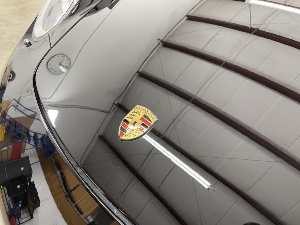 A black car with a porsche logo on the hood