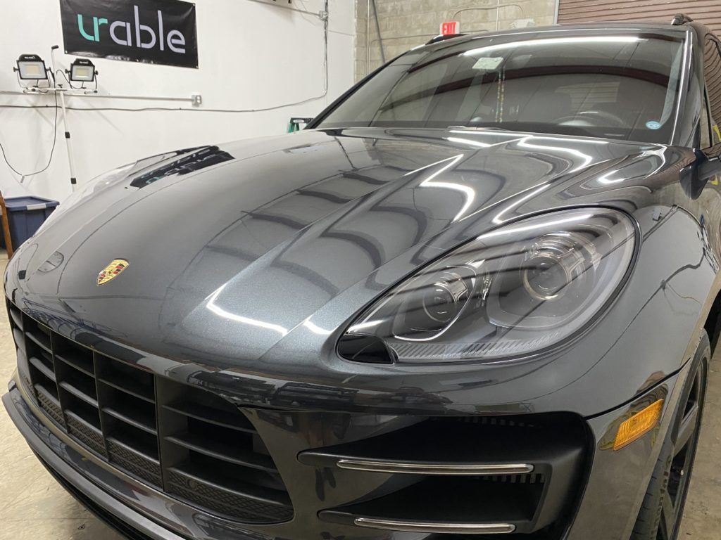 A black porsche macan turbo is parked in a garage.