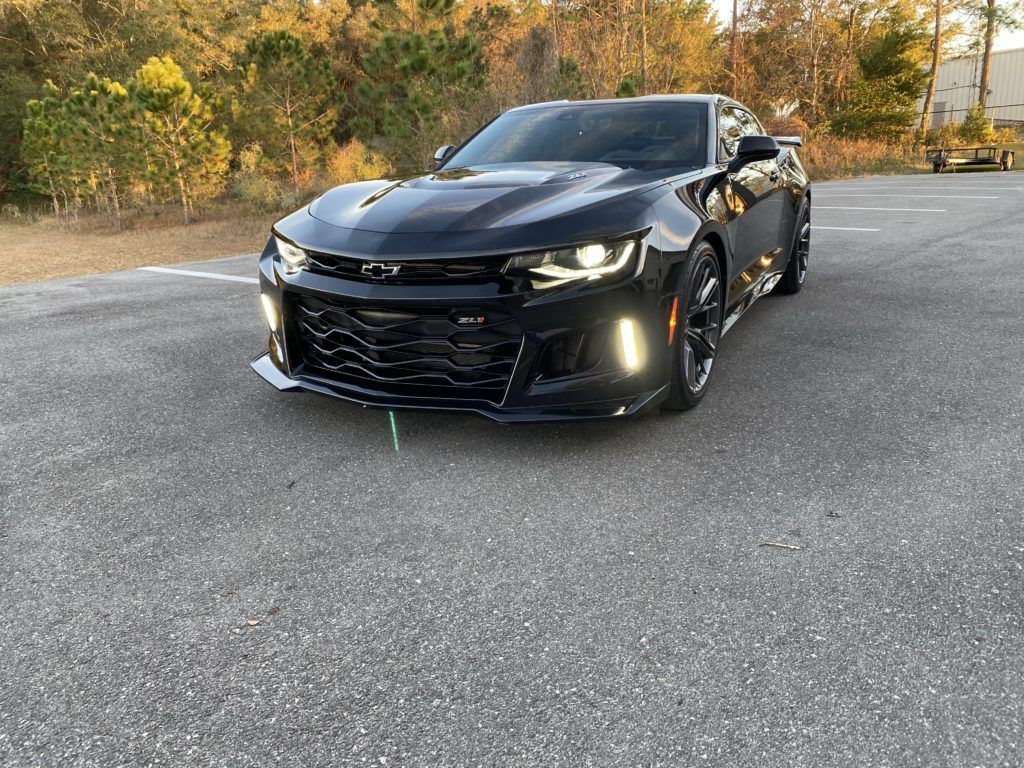 A black chevrolet camaro zl1 is parked in a parking lot.