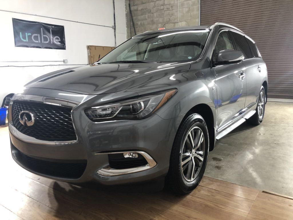 A gray infiniti q60 is parked in a garage.