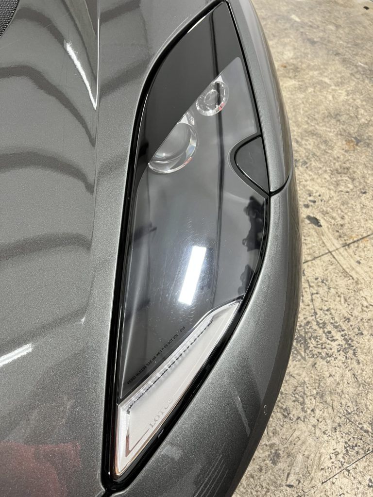 A close up of a car 's headlight in a garage.