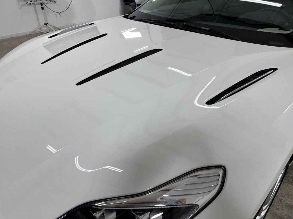 A close up of the hood of a white sports car.