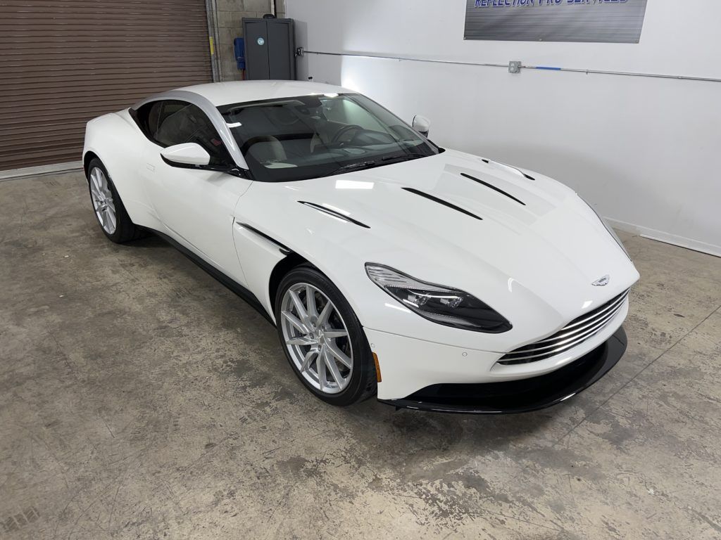 A white sports car is parked in a garage.