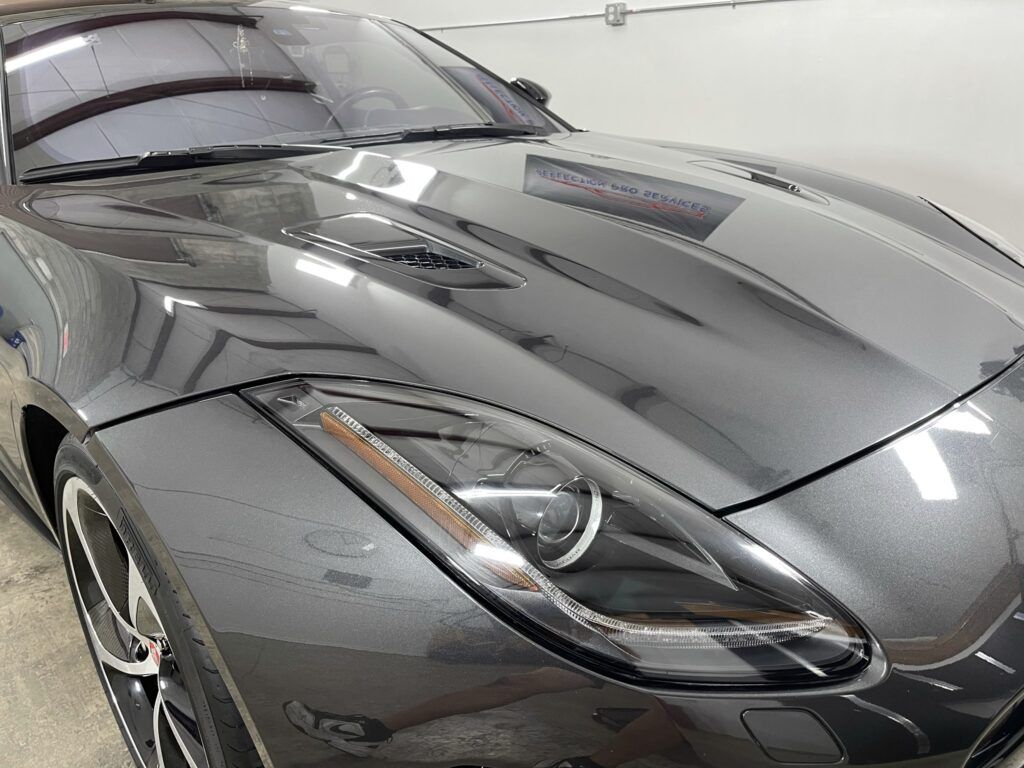 A black sports car is parked in a garage.