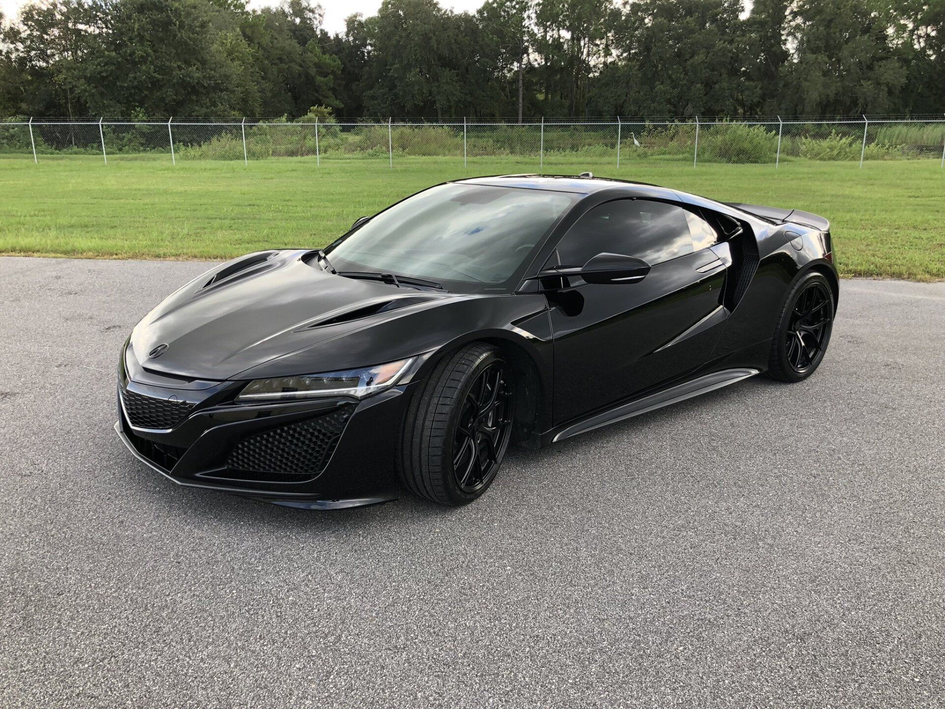 A black sports car is parked on the side of the road.