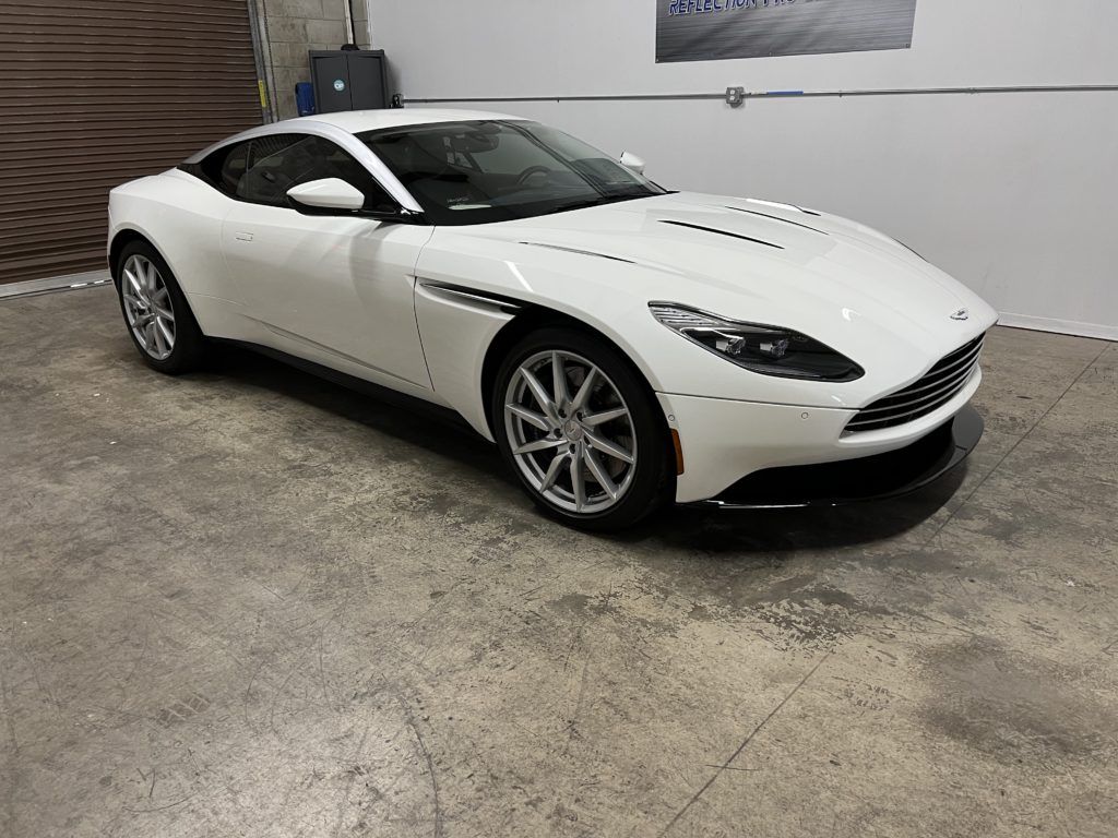 A white sports car is parked in a garage.