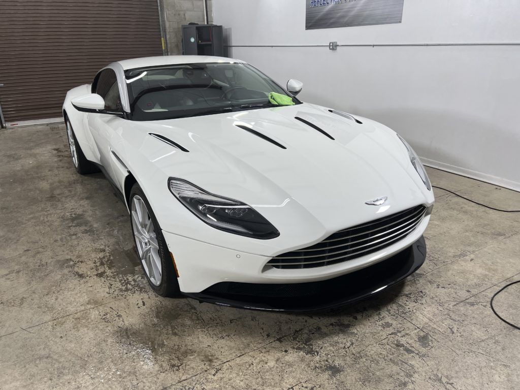 A white sports car is parked in a garage.