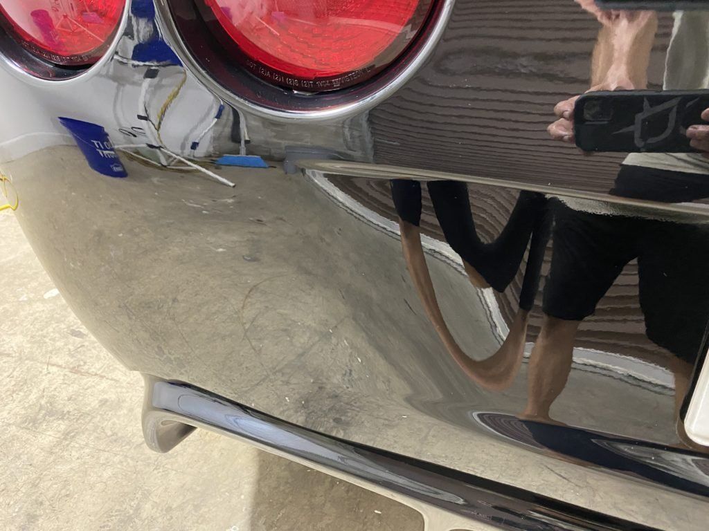 A person is taking a picture of their reflection in a car mirror.