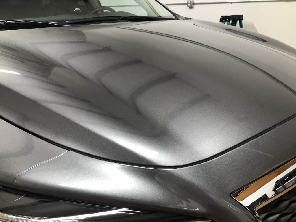 A close up of the hood of a car in a garage.