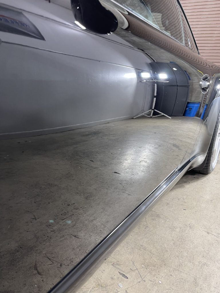 A close up of a car 's side in a garage.