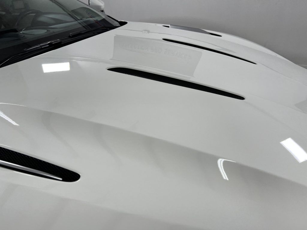 A close up of the hood of a white sports car.