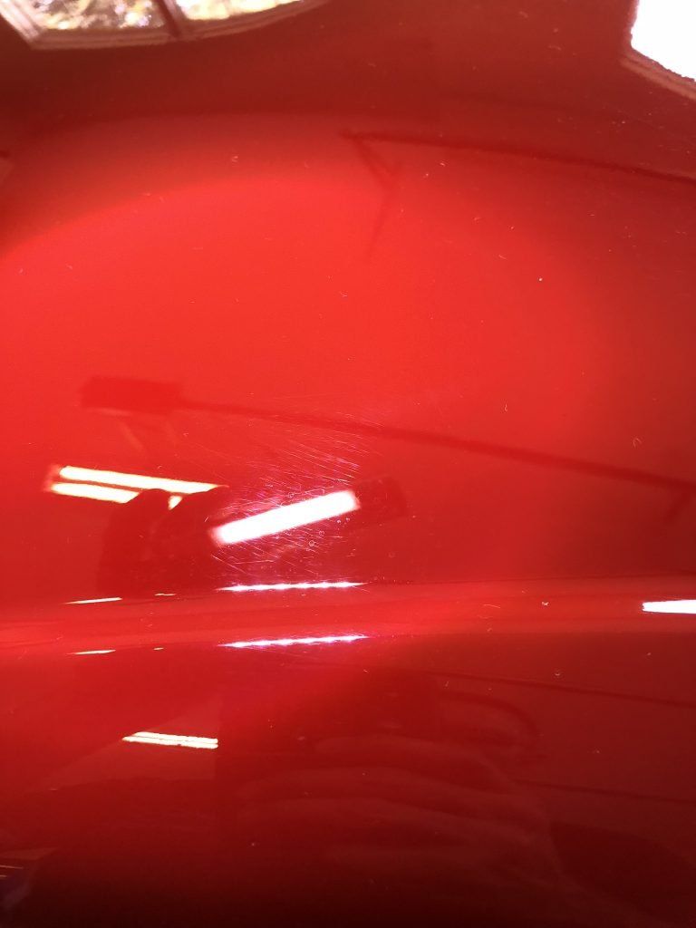A close up of a red car in a garage