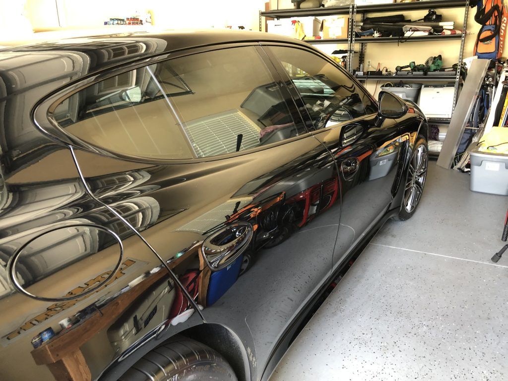A black car is parked in a garage.