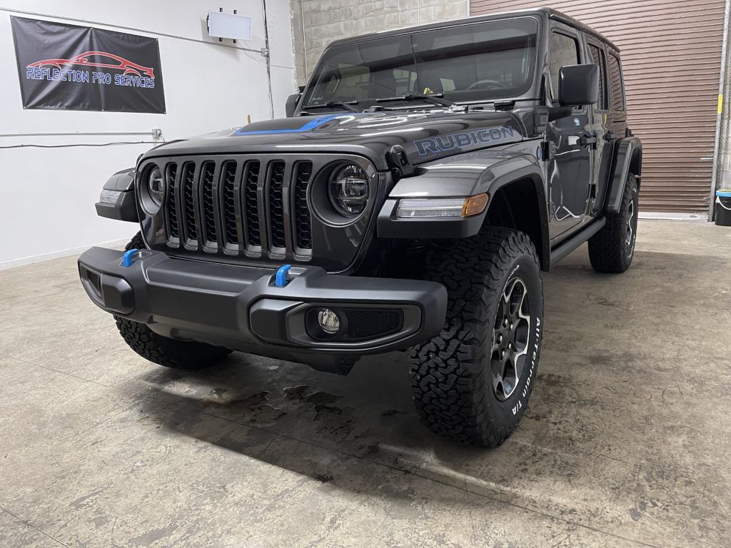 A black jeep wrangler is parked in a garage.