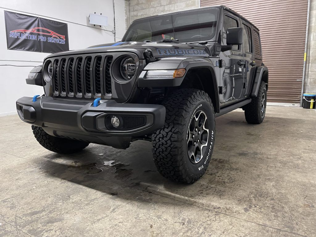 A black jeep wrangler is parked in a garage.