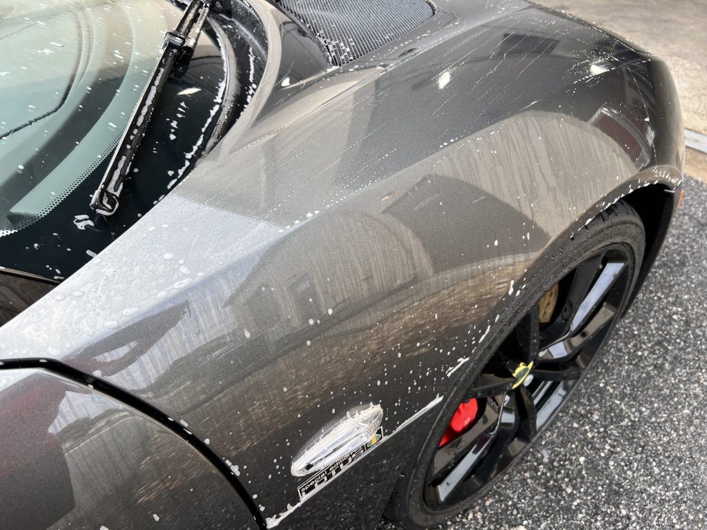A black car is parked on the side of the road.
