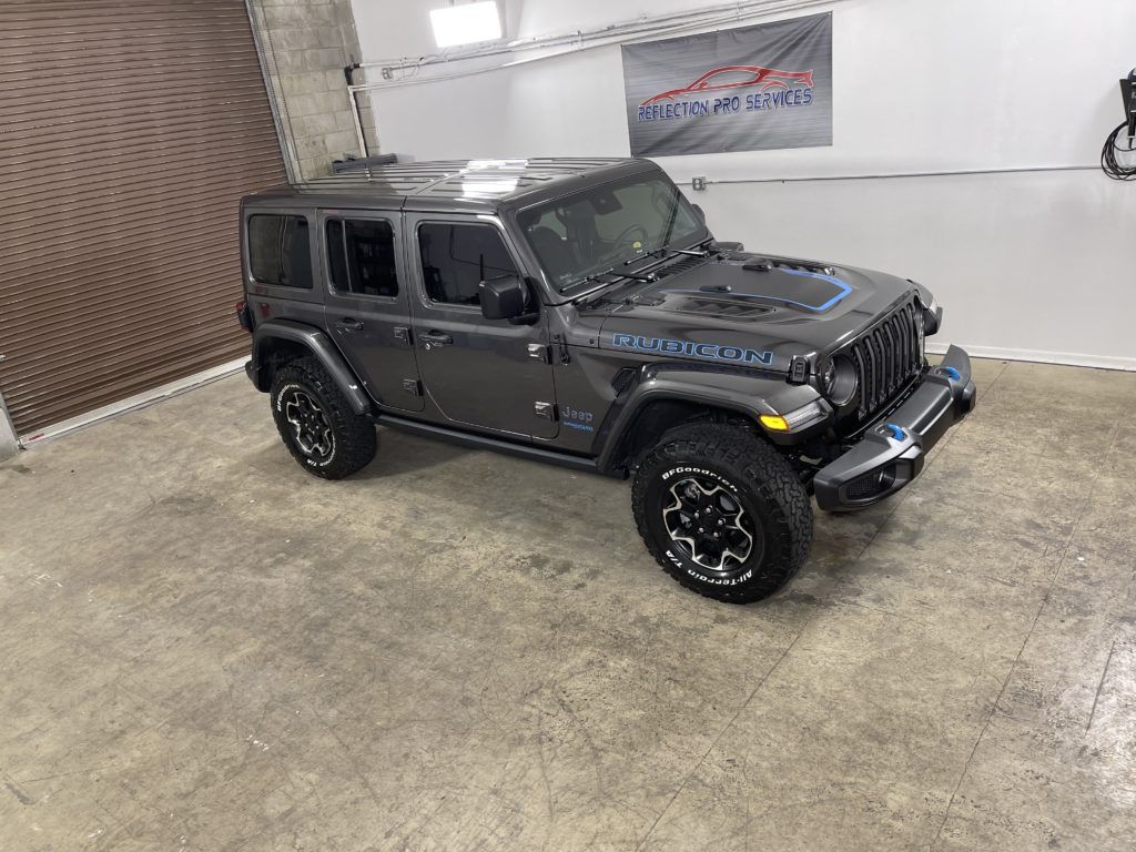 A jeep wrangler is parked in a garage.