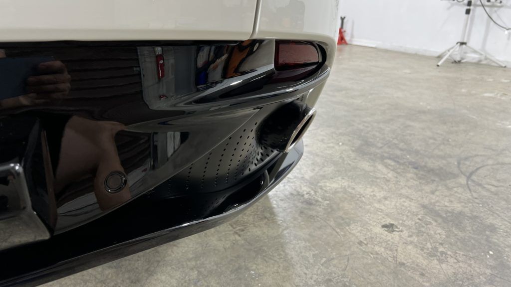 A close up of a car 's front bumper in a garage.