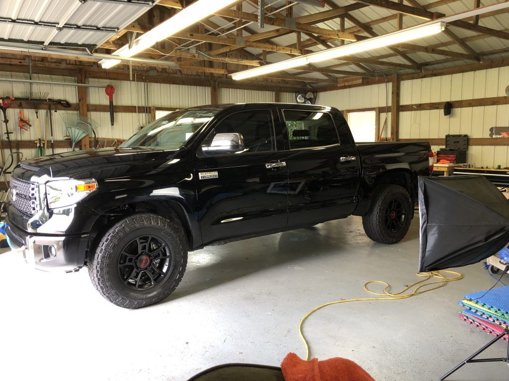 A black truck is parked in a garage.