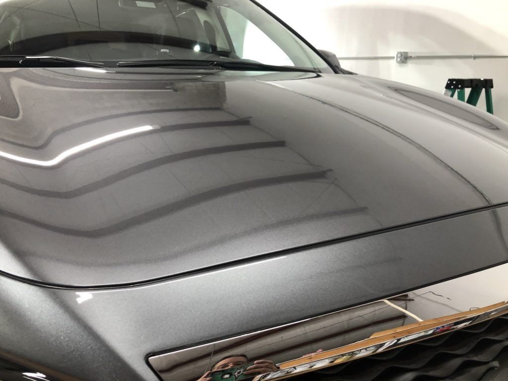 A close up of the hood of a car in a garage.