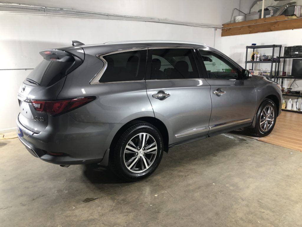 A gray suv is parked in a garage.