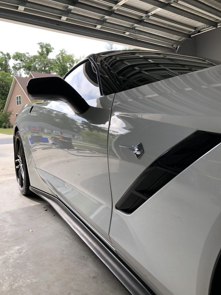 A silver sports car is parked in a garage.