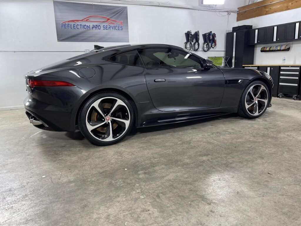 A jaguar f type is parked in a garage.