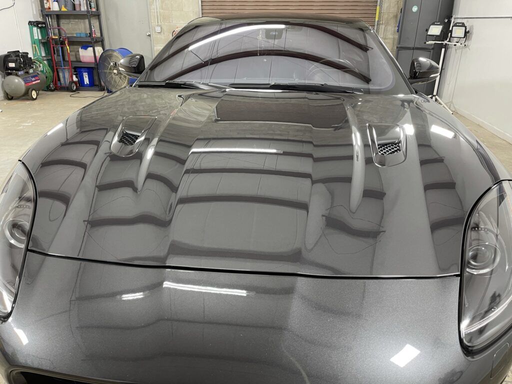 A gray sports car is parked in a garage.