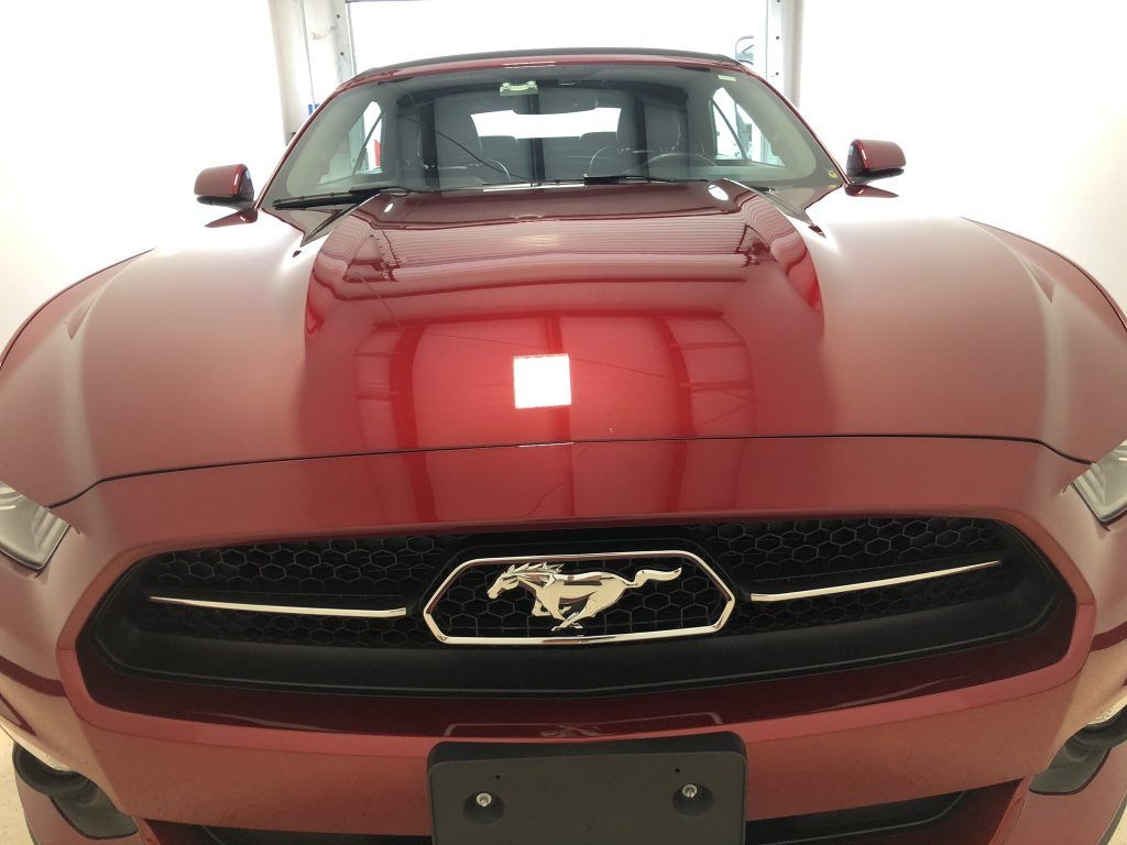 A red ford mustang is parked in a garage.
