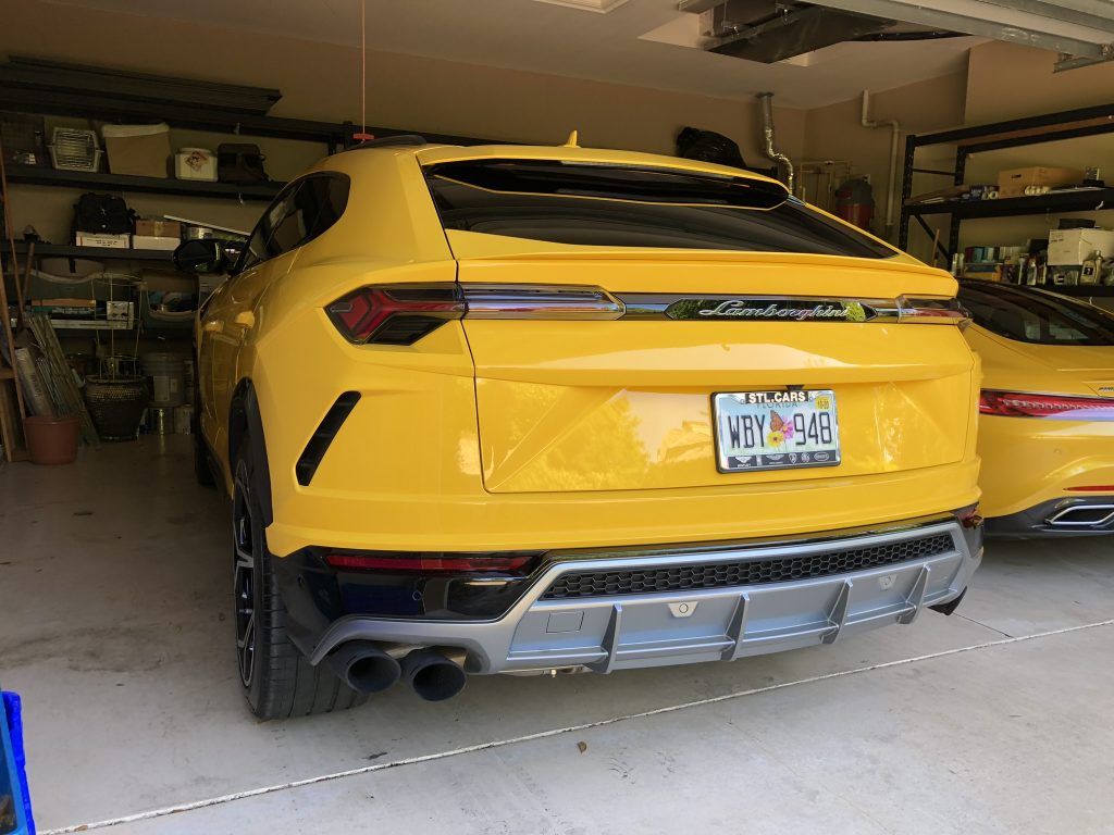 Two yellow lamborghini cars are parked in a garage.