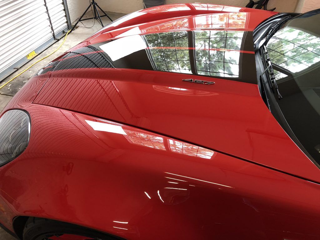 A red sports car is parked in a garage.