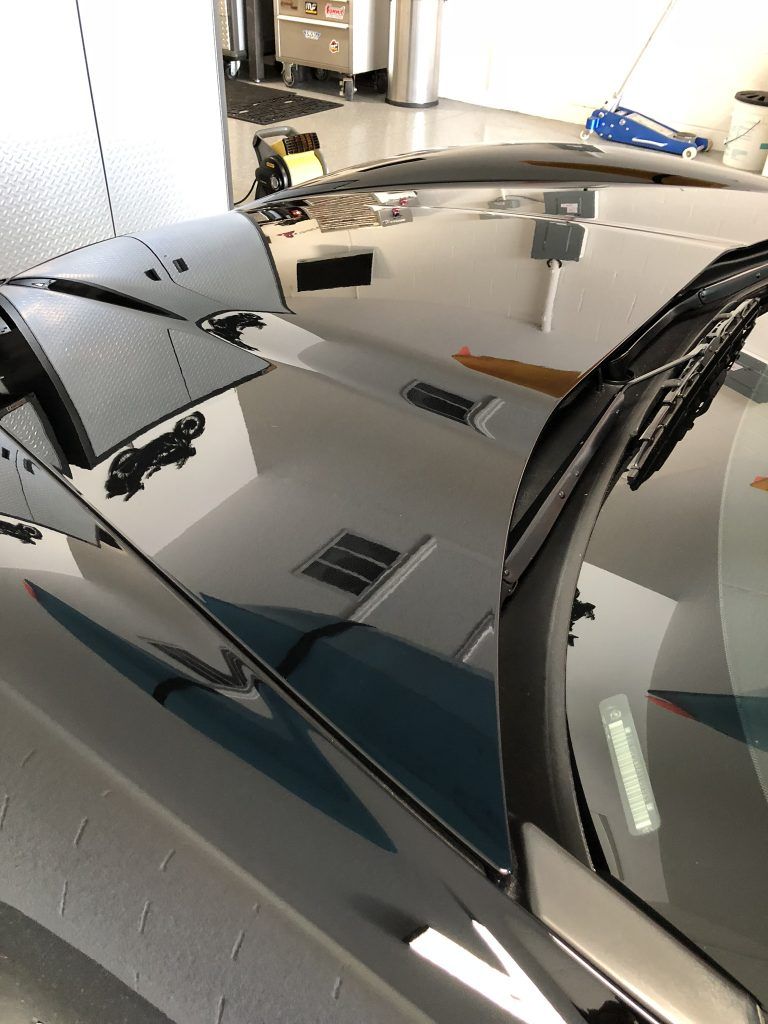 A close up of a car 's hood in a garage