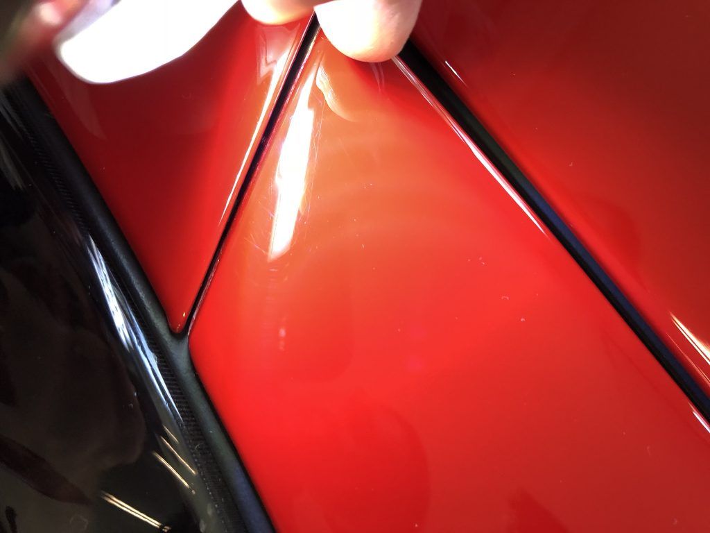 A close up of a person 's hand on a red car