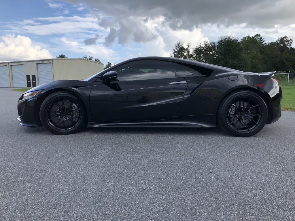 A black sports car is parked on the side of the road.