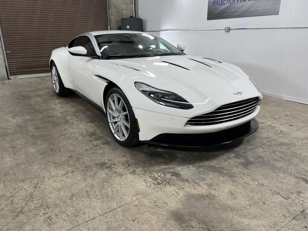 A white sports car is parked in a garage.
