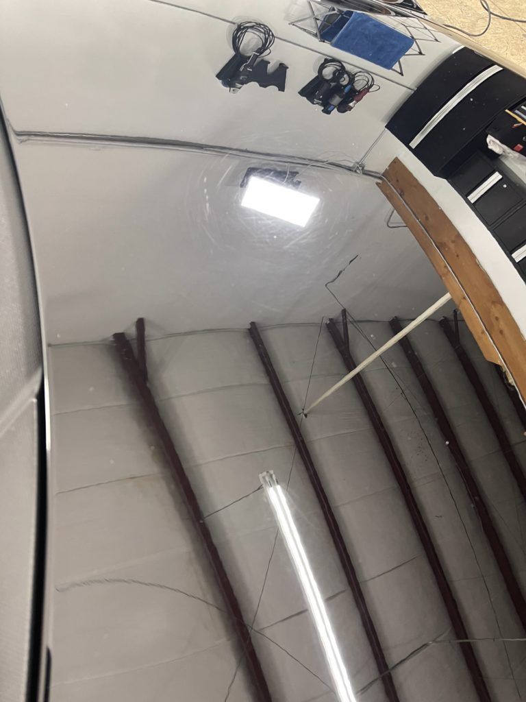 The ceiling of a building with a light hanging from it.