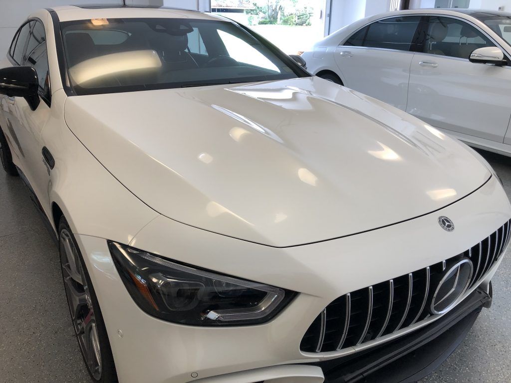 A white mercedes benz gt63 amg is parked in a garage.