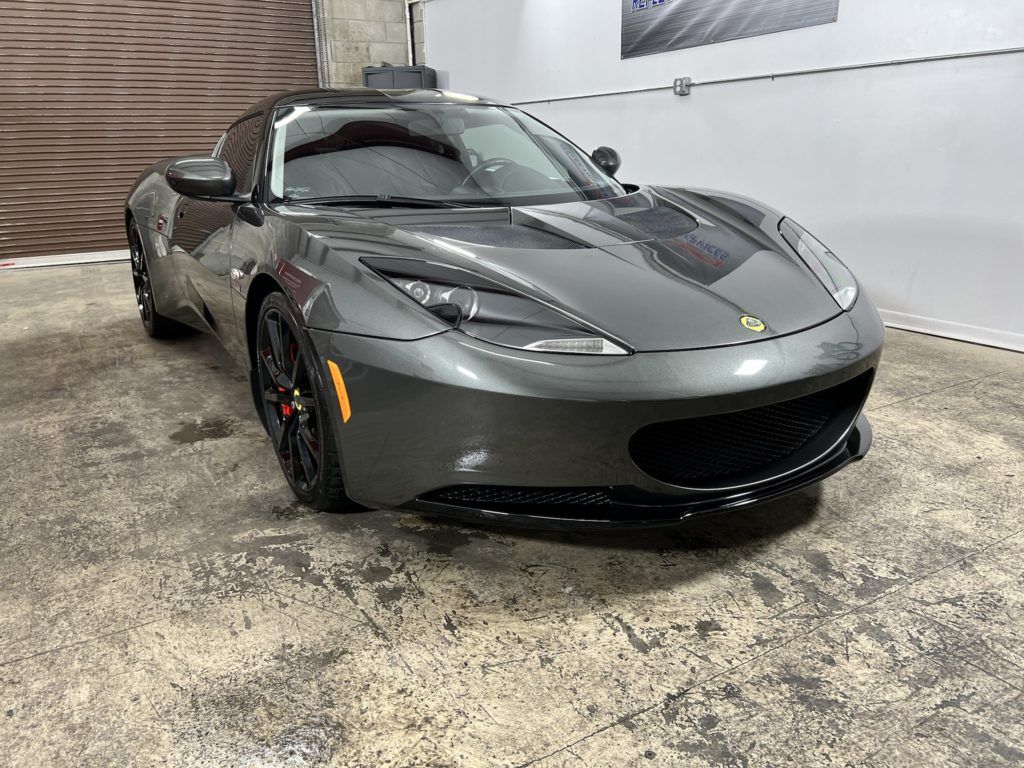 A gray sports car is parked in a garage.