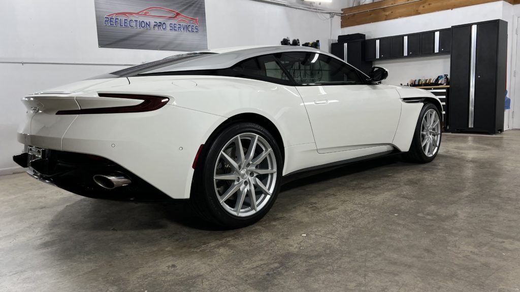 A white sports car is parked in a garage.