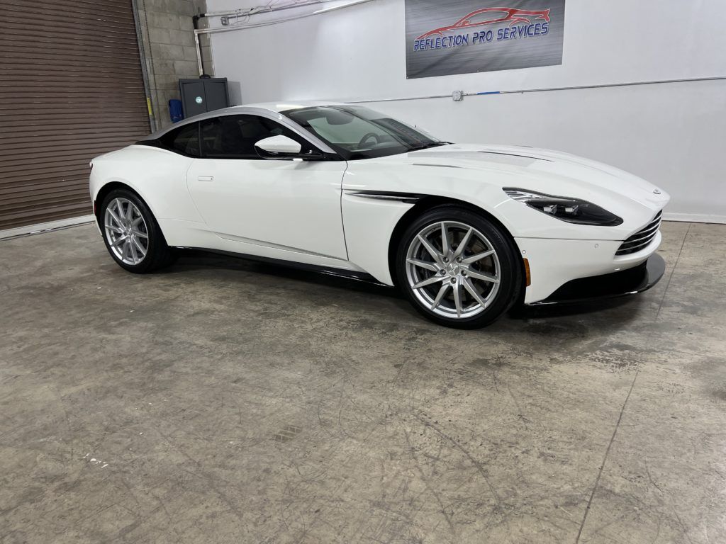 A white sports car is parked in a garage.