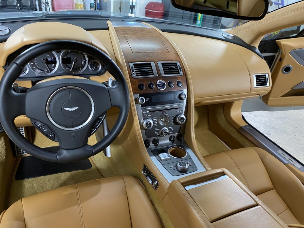 The interior of a car with a steering wheel and dashboard