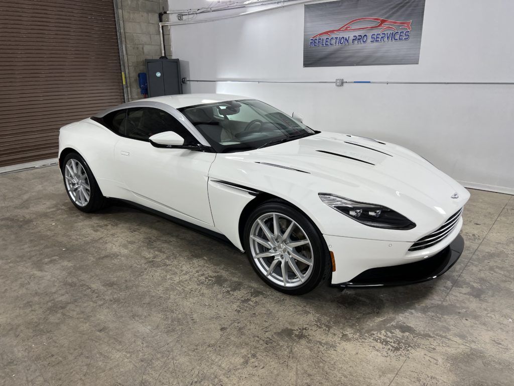 A white sports car is parked in a garage.